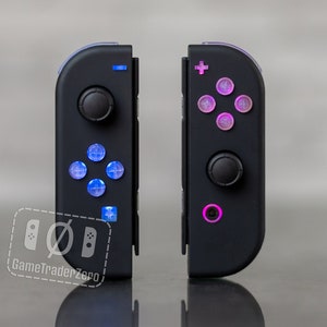 以下が含まれることがあります： カスタムフェイスボタン付きのブラックのニンテンドースイッチJoy-Conコントローラー2つ。左のコントローラーは青いフェイスボタン、右のコントローラーはピンクのフェイスボタンです。
