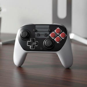 May include: A white and black wireless games controller with red action buttons. The controller features a D-pad, two analog sticks, and function buttons. The ergonomic design has a rounded shape for comfortable handling.