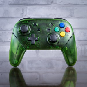 May include: A green transparent Nintendo Switch controller with black buttons and a directional pad. The controller has a clear, see-through design, revealing the internal components.