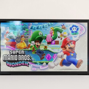 Pode incluir: Um console Nintendo Switch branco com Joy-Cons rosa e azul com um padr&atilde;o de estrelas e nuvens. O console est&aacute; exibindo o jogo Super Mario Bros. Wonder.