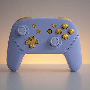 May include: A light blue Nintendo Switch controller with gold buttons and a gold directional pad.