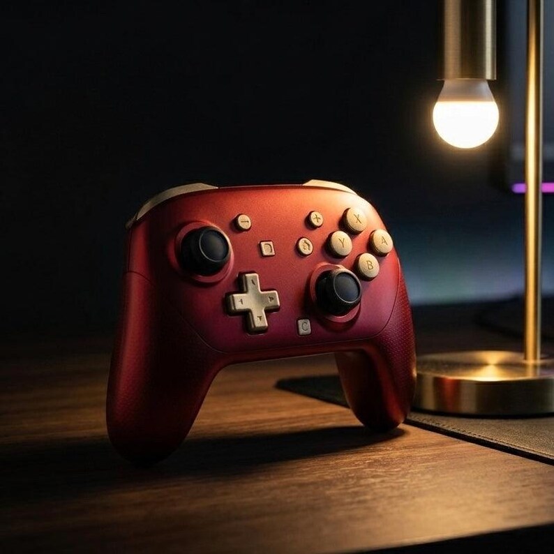 May include: A metallic red wireless game controller featuring gold-colored buttons, a gold directional pad, and two black analog sticks. The controller includes standard action buttons labeled A, B, X, and Y, along with menu and system function buttons.