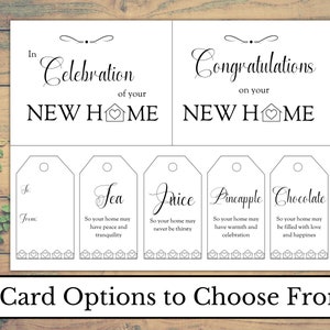 May include: Two printable cards for a housewarming gift. The top card says "In celebration of your new home" and the bottom card says "Congratulations on your new home".  The cards have a house icon with a heart in the middle.  The bottom of the card has five gift tags with different sayings for tea, juice, pineapple, chocolate, and a blank tag.