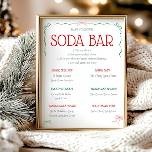 May include: A framed sign with the words "MAKE YOUR OWN SODA BAR" in red. The sign lists soda recipes like "Jingle Bell Pop" and "Santa Baby." The sign is decorated with green and red accents, and is set against a cozy, blurred background.