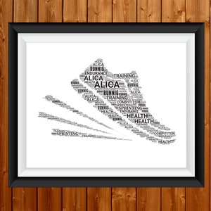 Op de afbeelding: Ingelijste print met een hardloopschoen-silhouet, samengesteld uit woorden als "ALICA", "RUNNIG", "TRAINING", "HEALTH", "ENDURANCE" en "COMPITITON". De zwarte lijst omringt een witte passe-partout, tegen een houten achtergrond.