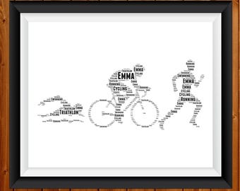 May include: Black framed print featuring a triathlon theme. The artwork depicts a swimmer, cyclist, and runner, each formed from words like "swimming," "cycling," and "running." The name "Emma" is also incorporated.