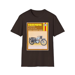 Puede incluir: Camiseta marrón oscuro con un gráfico de una motocicleta Triumph vintage y el texto "TRIUMPH Pre-unit Twins". El gráfico incluye el texto "OWNERS WORKSHOP MANUAL". La camiseta está hecha de un material suave y cómodo.
