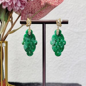 May include: A pair of green jade earrings with a butterfly design. The earrings are made of 14k gold and feature a delicate diamond accent.