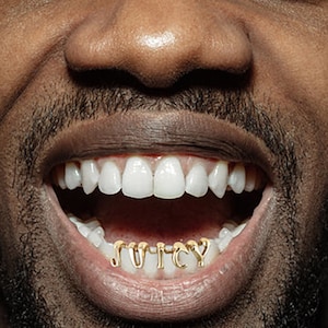 May include: A close-up of a person's mouth with gold teeth that spell out the word "JUICY".