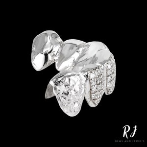 May include: Silver grill with diamond accents. The grill is made of metal and has a textured surface. The diamonds are set in the metal and are arranged in a pattern.
