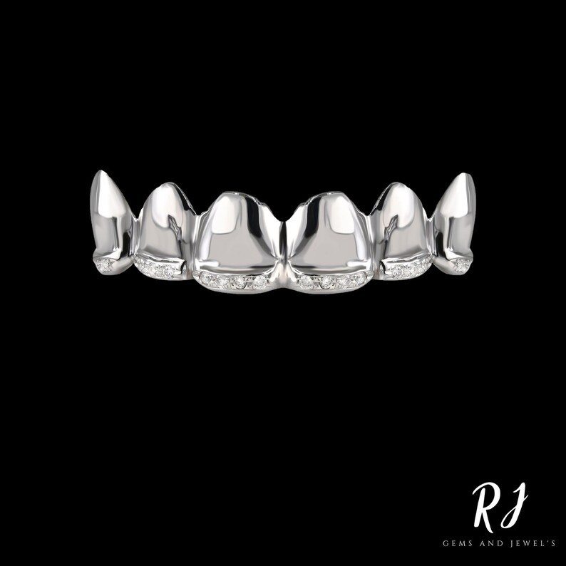 May include: A set of silver grillz with a row of small diamonds on each tooth.
