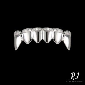 May include: A silver grill with a row of small diamonds on each tooth.