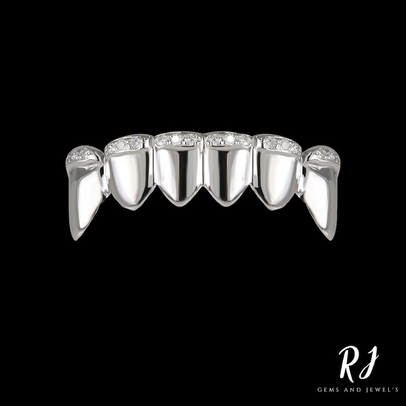 May include: A silver grill with a row of small diamonds on each tooth.