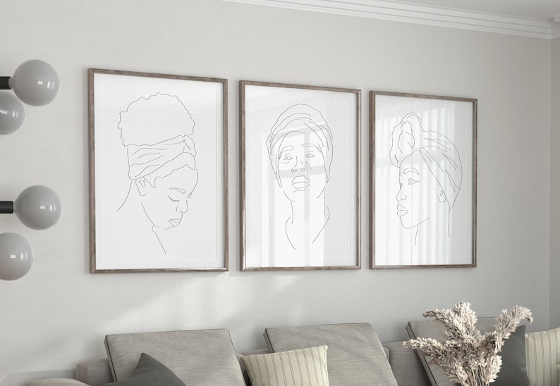 May include: Three framed line drawings of women with headscarves. The drawings are in black and white and are set against a white wall.