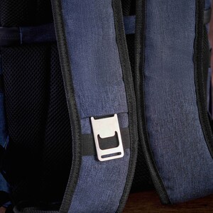 May include: A blue backpack with black straps and a silver buckle. The backpack is made of a textured fabric.