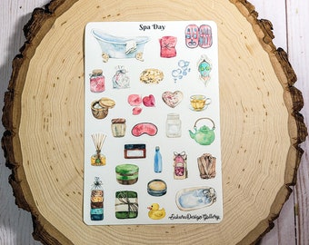 May include: A sticker sheet with watercolor illustrations of spa day items. Includes a bathtub, face mask, bath products, tea, and a rubber duck. The text "Spa Day" is at the top. The sticker sheet is on a wooden slice.