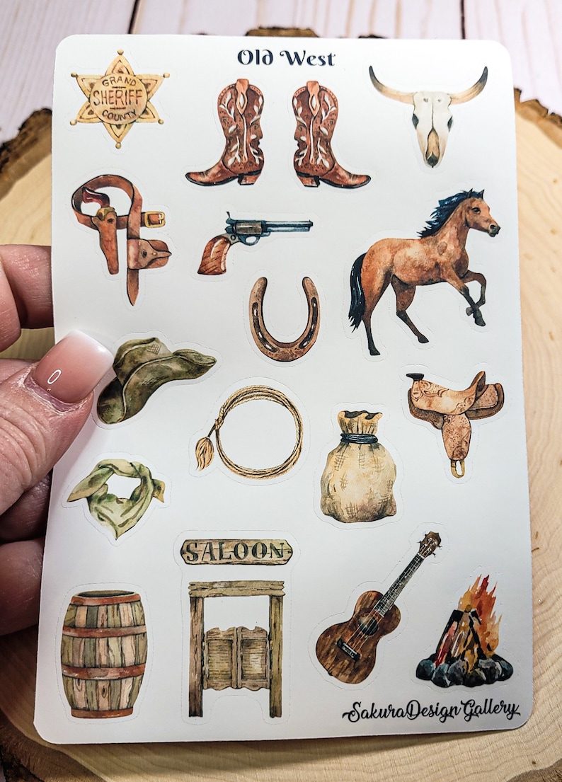 May include: A sheet of stickers with a Western theme. The stickers feature images of a sheriff's badge, cowboy boots, a skull, a horse, a gun, a horseshoe, a cowboy hat, a lasso, a saddle, a bandana, a saloon sign, a swinging saloon door, a guitar, and a campfire.
