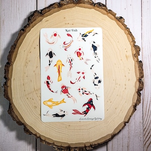 May include: A sheet of stickers featuring 18 different koi fish designs. The koi are illustrated in various colors, including red, white, black, and yellow. The stickers are labeled "Koi Fish" and "Sakura Design Gallery".