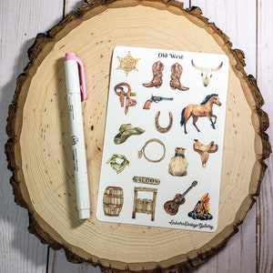 May include: A sheet of stickers with a western theme. The stickers feature images of a sheriff's badge, cowboy boots, a skull, a horse, a cowboy hat, a horseshoe, a lasso, a saddle, a bandana, a barrel, a saloon door, a guitar, and a campfire. The sheet is titled "Old West" and has the text "Sakura Design Gallery" at the bottom.