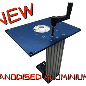 Könnte beinhalten: Ein blauer, eloxierter Aluminium-Frästisch mit schwarzem Griff und silbernem, kreisförmigem Einsatz. Das Wort "NEW" steht in Rot über dem Tisch, und "ANODISIERTES ALUMINIUM" steht in Rot darunter.