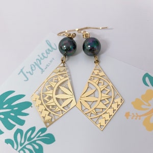 May include: Gold earrings with a geometric design and black pearl accents. Tropical Jewelry.