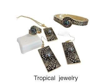 May include: A set of tropical jewelry featuring a gold bracelet, ring, earrings, and necklace. Each piece has a black and gold design with a dark gray pearl in the center.