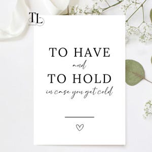 May include: White card with black text that reads "To Have and To Hold in case you get cold". There is a small heart at the bottom of the card.