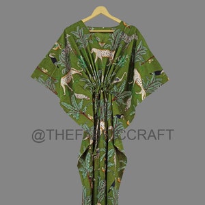 Op de afbeelding: Groene katoenen kaftan met een jungleprint met luipaarden, toekans en palmbomen. De kaftan heeft een trekkoord in de taille en een losse pasvorm.