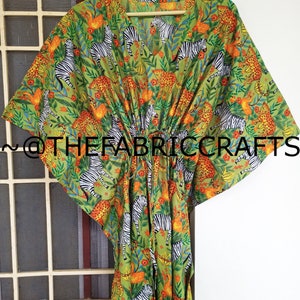 May include: A green kaftan with a zebra and leopard print. The kaftan has a V-neck and a tie at the waist. The fabric is soft and flowy.  @thefabriccrafts