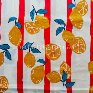 May include: A white fabric featuring a repeating pattern of vertical red stripes interspersed with yellow lemons and orange slices. Each fruit is accompanied by dark teal leaves. The text thefabriccraft is printed in white across the center.