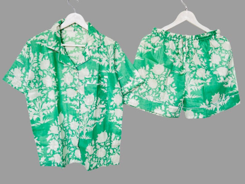 May include: A green and white floral print pajama set with a short-sleeved button-up shirt and matching shorts.