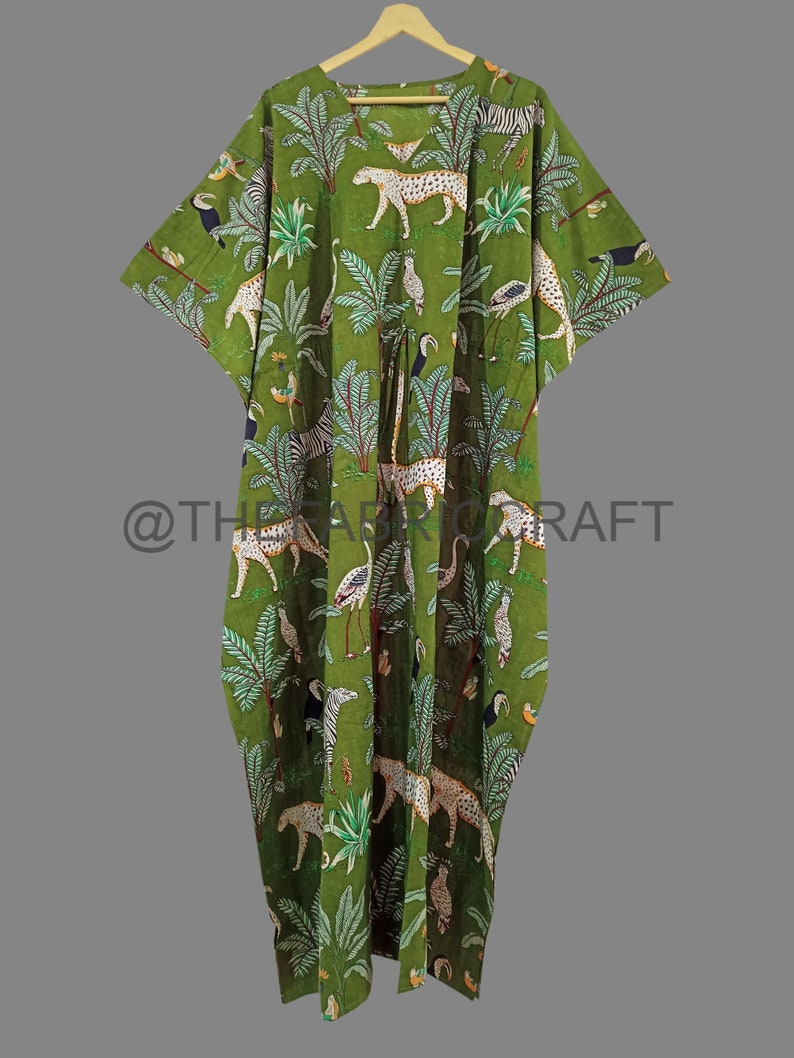 Op de afbeelding: Groene katoenen kaftan met een jungleprint met luipaarden, zebra's, toekans en palmbomen.