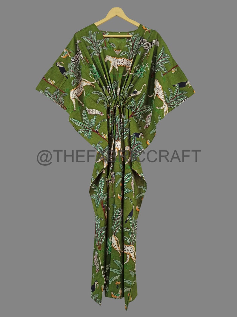 Op de afbeelding: Groene katoenen kaftan met een jungleprint met luipaarden, toekans en palmbomen. De kaftan heeft een trekkoord in de taille en een losse pasvorm.