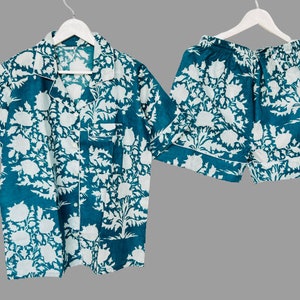 May include: A teal blue pajama set with a white floral print. The top has a collared neckline and short sleeves. The shorts have an elastic waistband.