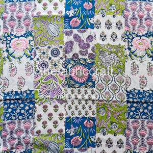 May include: A patchwork fabric with a floral design. The pattern features squares of white, green, blue, and purple, each with a different floral motif. Pink and white flowers are prominent, with green leaves and stems.