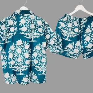 May include: A teal blue and white floral print pajama set with a short-sleeved button-up shirt and matching shorts.