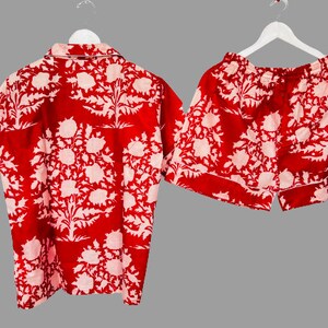 May include: Red and white floral print pajama set with a short-sleeved shirt and shorts.