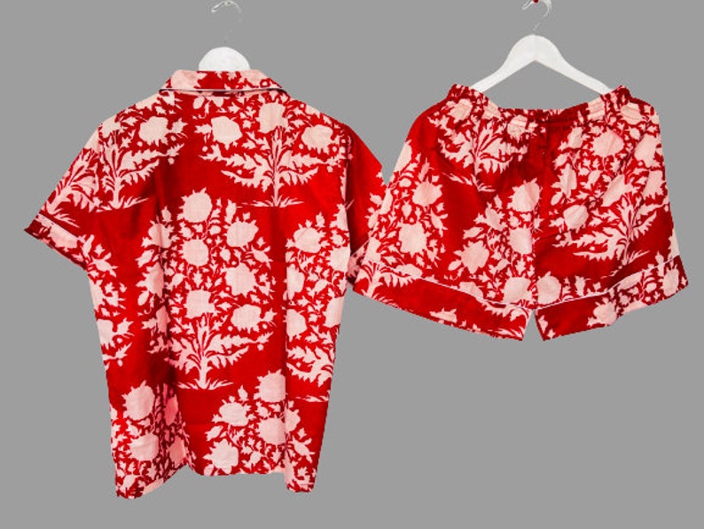 May include: Red and white floral print pajama set with a short-sleeved shirt and shorts.