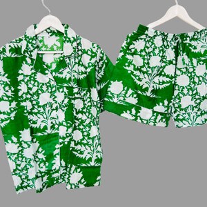 May include: A green and white patterned pajama set with a short-sleeved button-up shirt and matching shorts.