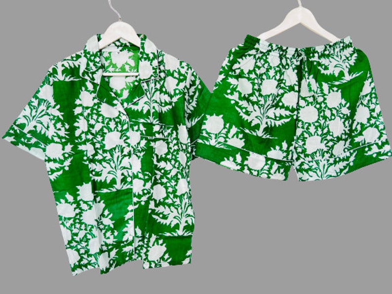 May include: A green and white patterned pajama set with a short-sleeved button-up shirt and matching shorts.