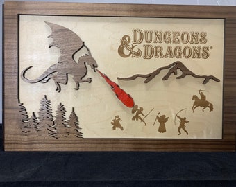 May include: Wooden framed artwork featuring a dragon breathing fire at a group of figures, with the text "DUNGEONS & DRAGONS". The artwork has a layered design with a dark brown frame and accents, and a light wood background.