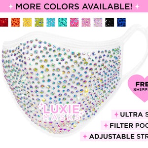 May include: White face mask covered in iridescent rhinestones. The mask has adjustable straps and a filter pocket. The text "Luxie Masks" is printed on the mask.  Free shipping is offered.