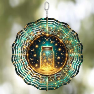 Op de afbeelding: Een decoratieve windspinner met een pot gevuld met gloeiende lichten en vuurvliegjes. De pot is gecentreerd in een cirkelvormig ontwerp met teal en gouden accenten. De spinner hangt aan een zilveren lus.