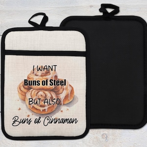 May include: A white and black pot holder with a brown and white illustration of cinnamon rolls. The text on the pot holder reads "I want buns of steel but also buns of cinnamon".