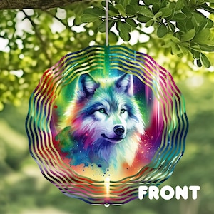 May include: A circular decoration with a detailed, colourful illustration of a wolf. The wolf has green eyes and is set against a rainbow-coloured background. The word "FRONT" is printed in white at the bottom. The ornament is hanging from a string.