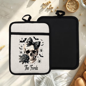 Peut inclure: Deux maniques sur le thème d'Halloween. L'une présente un motif de crâne avec un nœud noir, des araignées, des chauves-souris et une rose. Le texte "The Fords" est imprimé en dessous. L'autre est noir uni.