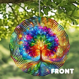 May include: A round, colorful wind spinner featuring a vibrant tree design. The tree is depicted with a rainbow of colors, including red, orange, yellow, green, blue, and purple. The word "FRONT" is printed in white at the bottom.