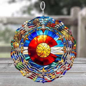 May include: A colorful stained glass wind chime featuring the Colorado state flag. The chime is made of metal and has a circular shape. The flag is depicted in the center of the chime, surrounded by a decorative border.