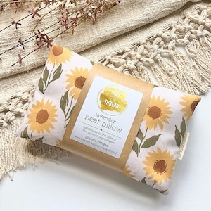May include: A lavender heat pillow with a sunflower print. The pillow is handmade in the hills of the Dandenong Ranges. The label reads "Snaz & Thread" and "lavender heat pillow".