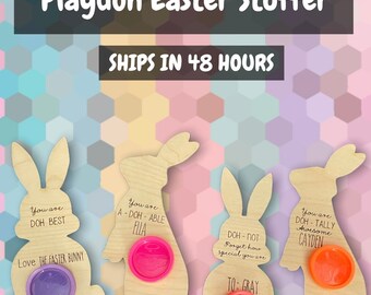 May include: Wooden Easter bunny-shaped Play-Doh stuffers with colorful Play-Doh containers. Each bunny has a unique message, such as "You are DOH BEST" and "Love THE FASTER BUNNY." The text "Playdoh Easter Stuffer" is at the top.